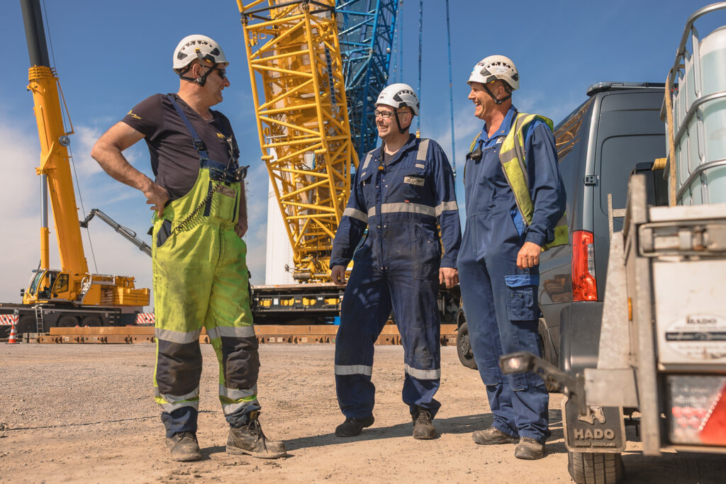 Werknemers in veiligheidskleding bij kraan op bouwplaats tijdens employer branding fotoshoot